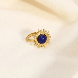 Détail d'une bague tournesol vintage avec pierre turquoise bleue sur soie texturée