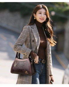 Outdoor street shot of a vintage crocodile pattern handbag with golden kangaroo logo