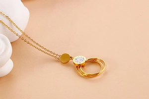 Detailed view of intertwined gold rings pendant with shimmering crystal embellishments