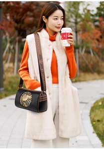 Detail of black crossbody bag with elephant embroidery and branded brown shoulder strap