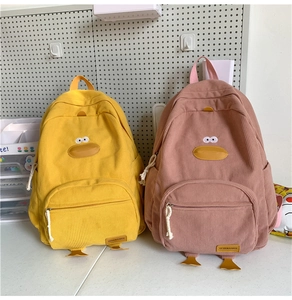 Detail of yellow and pink corduroy duck backpacks with 3D beak and embroidery