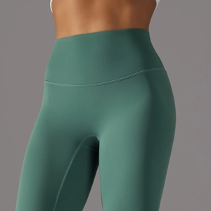 Detail of high-waist yoga leggings in dark green showing premium stretch fabric and stitching