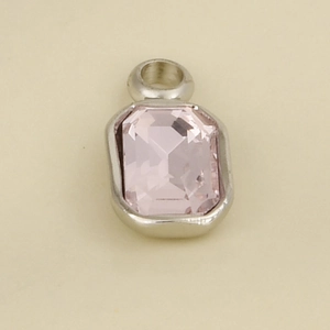Macro shot of 304 stainless steel pendant with pink rectangular gemstone and silver rim