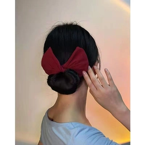 Vue détaillée d'un élégant accessoire chignon en tissu rouge foncé dans une coiffure