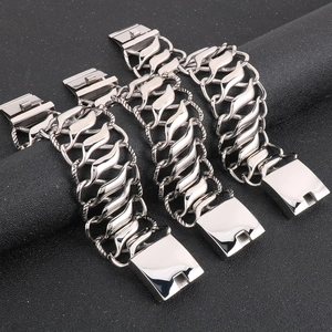 Detail of three wide polished stainless steel twist chain bracelets for men on black display
