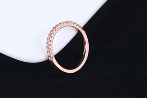 Detailed close-up of a rose gold ring set with a row of sparkling cubic zirconia gems