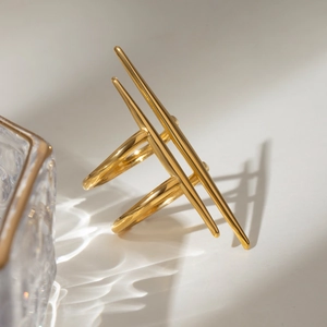 Detailed view of a gold double-bar geometric ring with artistic light and shadow effects