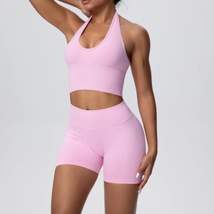 Detail of pink seamless knit yoga set featuring ribbed high waistband and halter neck top