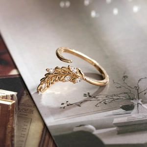 Macro detail of leaf ring with cubic zirconia stones on vintage magazine background
