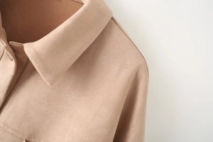 Detailed macro view of the lapel and stitching on the camel suede jacket fabric