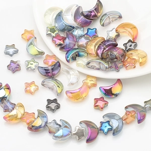 Macro shot of iridescent moon and star glass beads for DIY jewelry making and crafts