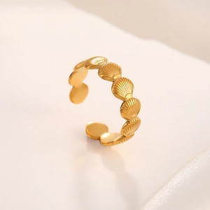 Detailed macro view of gold seashell pattern texture on stainless steel adjustable ring