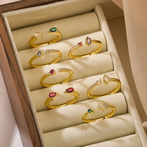 Set of eight gold plated adjustable rings with colorful zircon in a wooden jewelry box