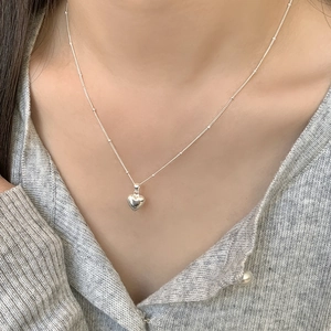 Minimalist 925 sterling silver heart pendant necklace with fine beaded chain on a model