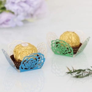 Détail d'un plateau en papier découpé au laser avec motifs de roses pour chocolats en bleu et vert