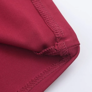 Detailed macro view of wine red knitted dress showing fine stitching and fabric texture