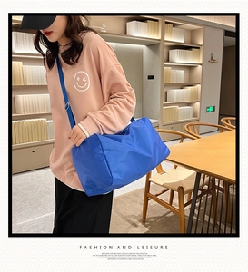 Dettaglio della borsa da viaggio in nylon blu reale con tracolla regolabile sul modello
