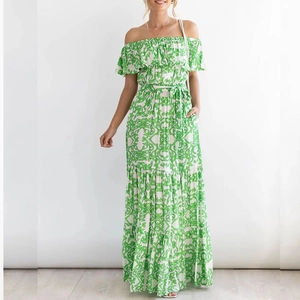 Detail view of the green bohemian floral print on off-shoulder maxi dress fabric