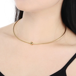 Detailed close-up of a gold twisted wire choker necklace with a central metal bead