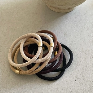 Minimalist high-elasticity hair ties in neutral tones with cylindrical gold metal buckles