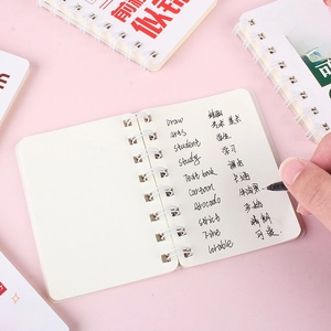 A7 spiral notebook with double-wire binding and white pages being written on with a pen