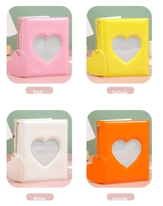 Four colors of mini photobooks with heart cutouts and matching heart pendants in a grid