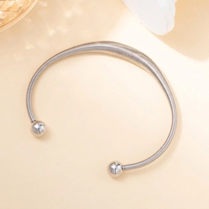 Macro shot of silver-toned coiled spring choker necklace with metallic ball ends