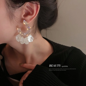 Gros plan sur un mannequin portant des boucles d'oreilles en C avec pétales blancs