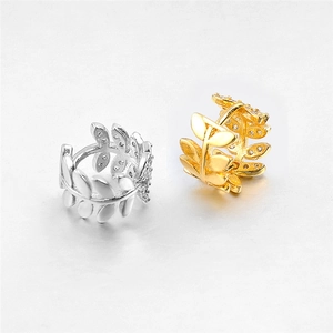 Close-up of gold and silver branch leaf ear cuffs with sparkling zircon stone settings