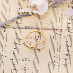 Detailed view of cat-shaped gold ring with oval gemstone on vintage sheet music