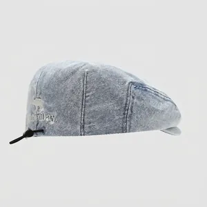 Dettaglio del berretto in denim azzurro per bambini con coulisse regolabile e ricamo