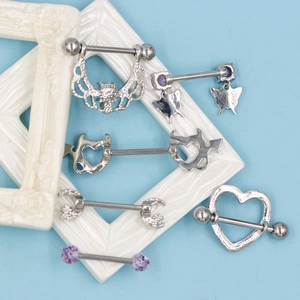 Flat lay of purple zircon heart and butterfly nipple rings on a blue background