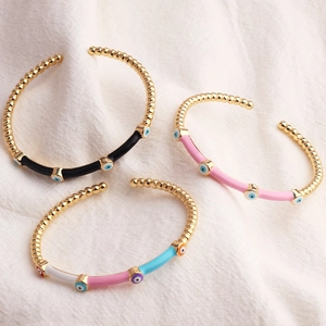 Detail of gold-plated bamboo joint bracelets with colorful evil eye enamel charms