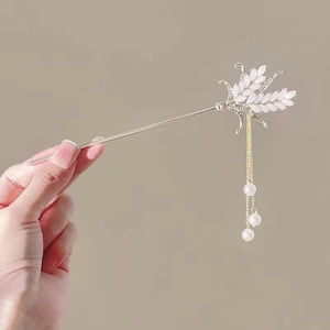 Detail of silver magnolia hair stick with wheat leaf design and three hanging pearls