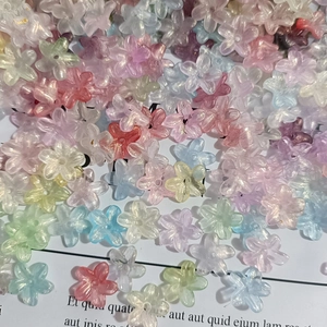 Close-up of colorful gradient floral resin beads with gold foil for DIY nail art designs