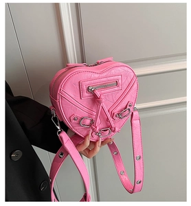 Détail du sac coeur rose style motard avec rivets métalliques et texture cuir froissé