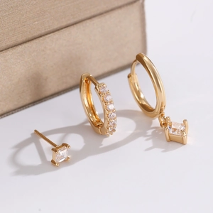 Macro shot of gold-plated earrings set with sparkling square-cut zircon stones
