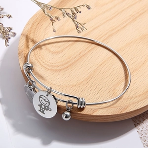 Silver adjustable wire bracelet with heart pendant and Love engraving on a tray