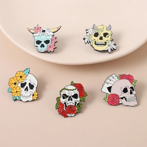 Set of 5 skull enamel pins with colorful flower and devil motifs on beige background