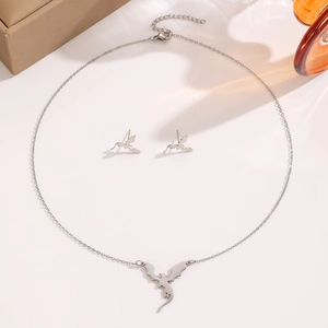 Vue détaillée de l'ensemble de bijoux dragon argenté comprenant collier et boucles d'oreilles