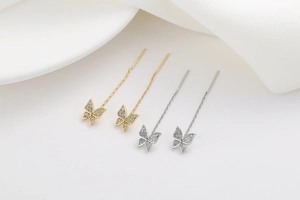 Macro shot of gold and silver butterfly threader earrings with zircon pavé details