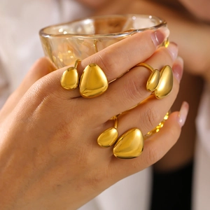 Minimalist 18K gold plated irregular geometric rings set on model holding glass