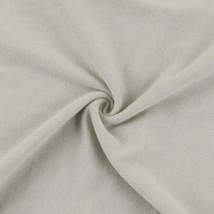 Macro detail van beige gebreide stof met zachte textuur en luxe valling van de jurk
