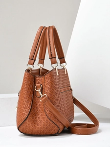 Detail of brown woven texture handbag with detachable strap and gold-tone hardware