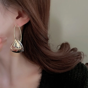Close-up of model wearing stylish golden geometric hollow triangle drop earrings