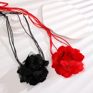 Close-up of lightweight chiffon fabric petals on a large floral necklace in red and black