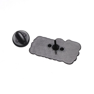 Detail view of the metal pin badge back with textured anti-slip plate and black rubber clutch