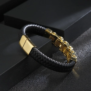 Detail of black leather and gold bicycle chain link bracelet with magnetic clasp