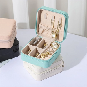 Detail of portable jewelry box with necklace hooks and multi-compartment interior storage