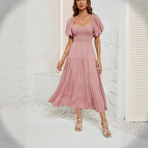 Robe longue rose à manches bouffantes, taille haute, jupe à volants et bustier smocké